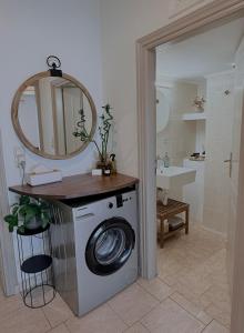 a bathroom with a washing machine and a mirror at Selini Apartments Mani in Agios Nikolaos