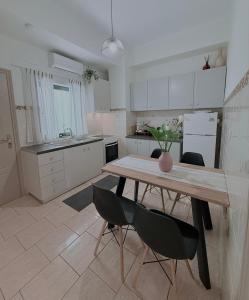 a kitchen with a wooden table and two chairs at Selini Apartments Mani in Agios Nikolaos