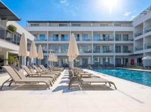 a hotel pool with lounge chairs and umbrellas at Victoria Princess Hotel in Side