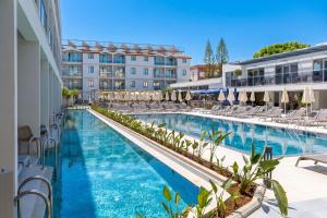 a pool at a hotel with chairs and umbrellas at Victoria Princess Hotel in Side