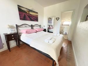 a bedroom with a large bed with pink pillows at Cà Bianca in Casorzo