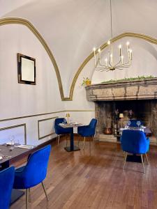 a dining room with blue chairs and a fireplace at Château De La Caze Piscine & Spa - Ste Enimie in Sainte-Énimie