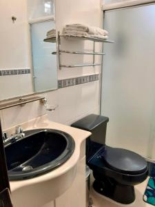 a bathroom with a black toilet and a sink at Hospedaje en Quito Norte, Apartamento & Suite independientes in Quito +23 photos
