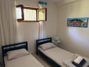 two beds in a small room with a window at Siviri Serenity, 3 minutes walk from the Beach in Siviri +16 photos