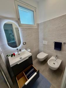 a bathroom with a sink and a toilet and a mirror at Lakeview in Luino +74 photos