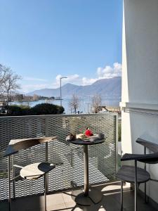 a table and chairs on a balcony with a view at Lakeview in Luino