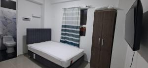 a small bedroom with a bed and a toilet at La torre in Lurín