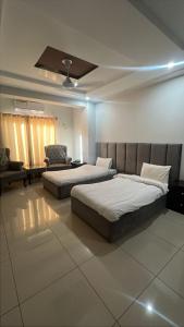 a bedroom with two beds and a couch at We Hotels in Islamabad