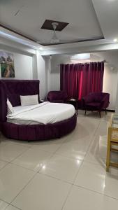 a bedroom with a large bed and red curtains at We Hotels in Islamabad