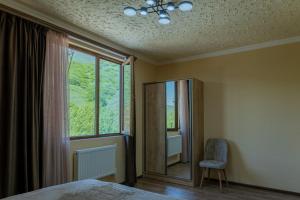 a bedroom with a bed and a window and a chair at Old House Residence Aghveran & Restaurant in Arzakan