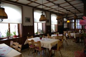 un restaurante con mesas, sillas y ventanas en Gasthaus Finken, en Oppenau