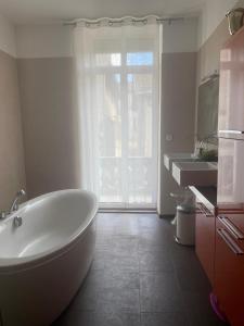 a bathroom with a white tub and a sink at Chambres Senta Fe in Sainte-Foy-la-Grande
