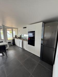 a kitchen with white cabinets and a stainless steel refrigerator at JPY S Suite in Pointe-à-Pitre