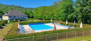 a large swimming pool with chairs and a building at Superbe duplex les belles Rives Argentat bords Dordogne avec wifi in Argentat