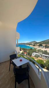 a balcony with a table and chairs and the ocean at Seli's White Villa in Ksamil