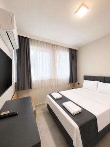 a hotel room with a large bed and a television at Kaya Hotel in Antalya