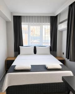 a bedroom with a large bed with two pillows on it at Kaya Hotel in Antalya
