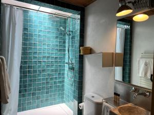 a bathroom with a shower with blue tiles on the wall at Barrieiro - Art & Nature in Marvão +161 photos