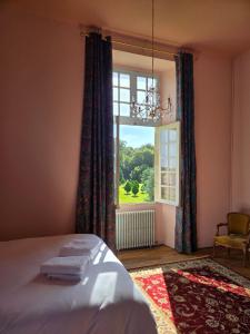 a bedroom with a bed and a large window at Château de Beaumanoir in Évran +13 photos