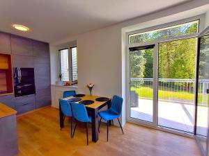 a kitchen and dining room with a table and blue chairs at Residence Pod Bublavou in Kraslice