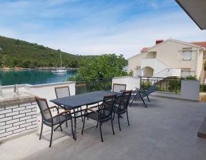 a table and chairs on a balcony with a view of a river at Captain Ante's House in Dragove