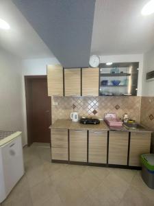 a kitchen with wooden cabinets and a counter top at Jadran5 in Petrovac na Moru +6 photos