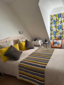 a bedroom with a large bed with yellow and blue pillows at Superbe duplex les belles Rives Argentat bords Dordogne avec wifi in Argentat +70 photos
