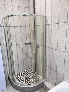 a shower with a glass door in a bathroom at Human on Ten BnB in Summer Pride