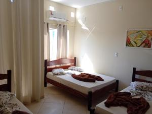 a room with two beds and a window at Pousada Rota da Luz in Aparecida