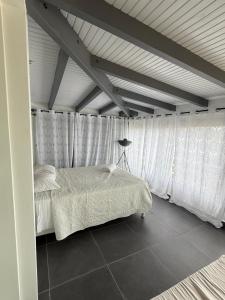 a bedroom with a bed with white sheets and curtains at JPY S Suite in Pointe-à-Pitre +3 photos