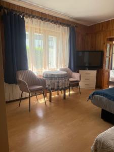 a living room with two chairs and a table and a tv at Tleniowo in Tleń