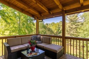 a screened porch with two chairs and a table at Beaver Rock Lodge in Elk Park