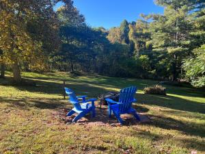 two blue chairs and a grill in a park at Beaver Rock Lodge in Elk Park