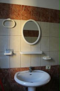 a bathroom with a sink and a mirror on the wall at La Famiglia Villa in Velipojë +35 photos