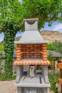 a grill sitting on a table in front of a tree at Camping Port Massaluca in Pobla de Masaluca
