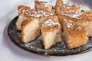 a plate of cake with powdered sugar on it at La Famiglia Villa in Velipojë