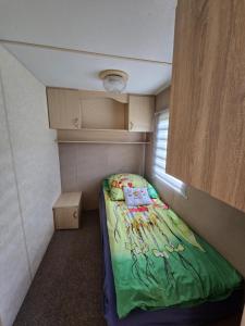 a small bedroom with a bed in a small room at Domki u Agi in Głęboczek