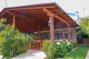 a wooden pavilion with a table and chairs in a garden at La Famiglia Villa in Velipojë