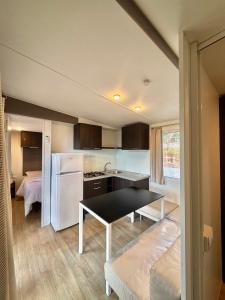 a kitchen with a table and a white refrigerator at Chrissa Camping Rooms & Bungalows in Delphi