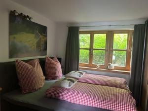 a bedroom with a bed with checkered pillows and a window at Apartment Andal in Lenggries