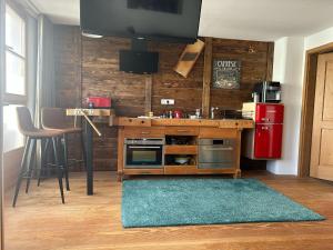 a kitchen with a tv and a table and a refrigerator at Apartment Andal in Lenggries
