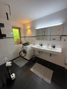a white bathroom with a sink and a window at Apartment Andal in Lenggries