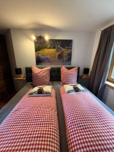 two beds with cats sitting on them in a room at Apartment Andal in Lenggries +6 photos