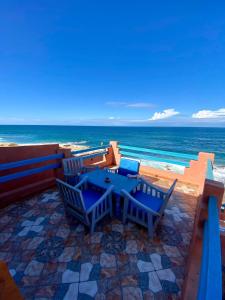 a patio with a table and chairs on the beach at Grotte pied dans l'eau in Aglou +10 photos