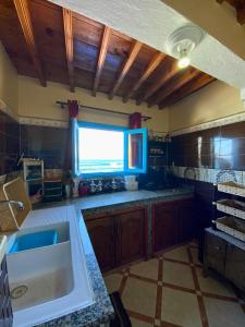a large kitchen with a sink and a window at Grotte pied dans l'eau in Aglou