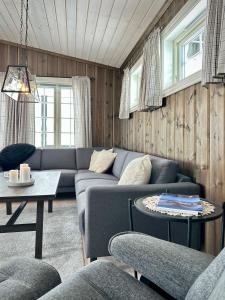 a living room with a couch and a table at High-standard cabin with jacuzzi & stunning views in Øyer