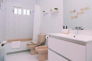 a white bathroom with a toilet and a sink at Casa Meiramar in Moaña +39 photos