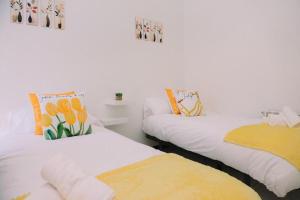 two beds in a room with orange and yellow pillows at Casa Meiramar in Moaña