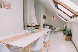 a white dining room with a white table and chairs at Casa Meiramar in Moaña