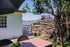 a patio with a table and a stone wall at Casa Meiramar in Moaña